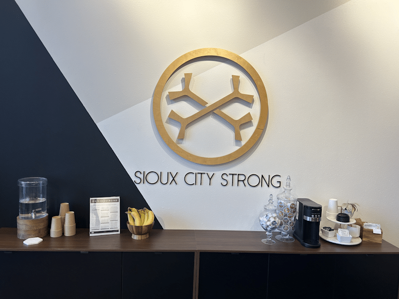 OsteoStrong Sioux City reception area with logo wall & front desk.