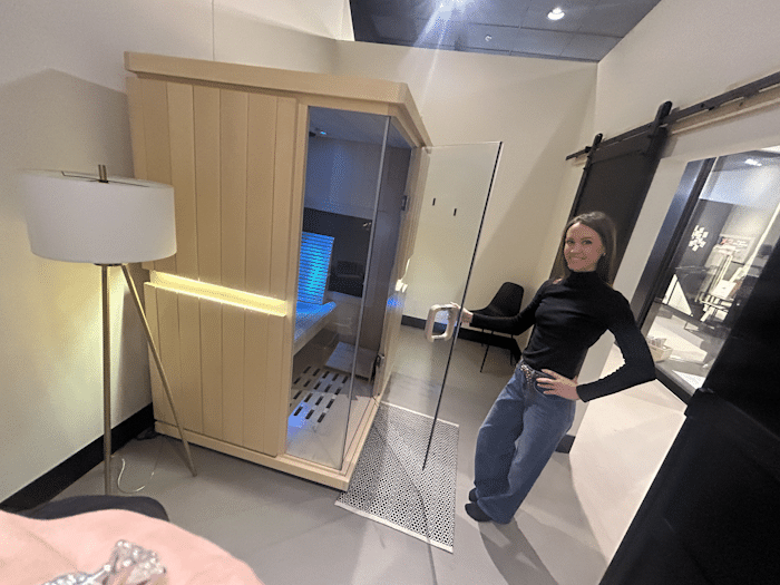 OsteoStrong Sioux City member standing next to a sauna.